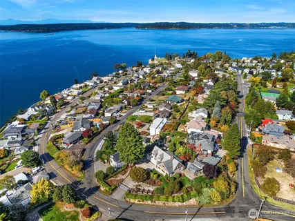 an aerial view of ocean and residential houses with outdoor space
