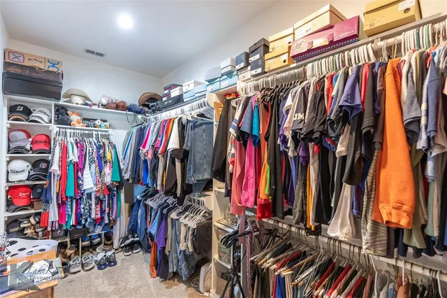 a view of walk in closet with clothes