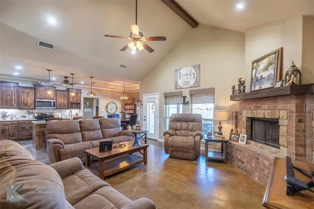 a living room with furniture kitchen view and a fireplace