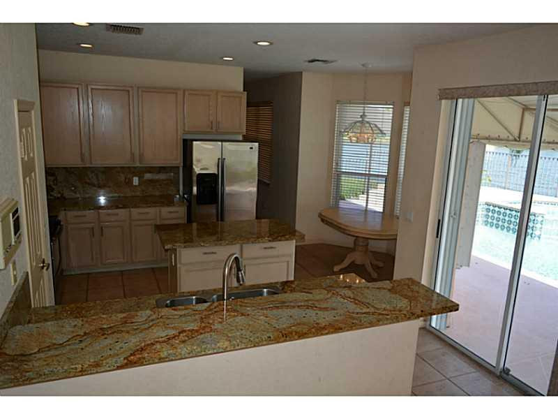 12656 Tucano Circle Boca Raton, FL 33428 - Photo 6 of 12 a kitchen with stainless steel appliances granite countertop a sink refrigerator and cabinets