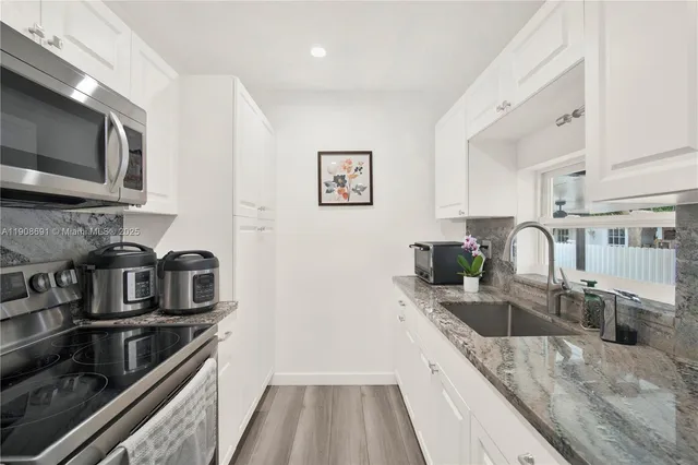 a kitchen with stainless steel appliances granite countertop a sink and stove top oven