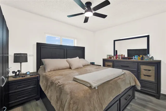 a bedroom with a bed and a lamp on dresser