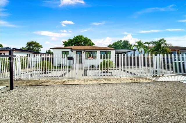 a view of a house with a small yard and wooden fence