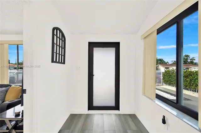 a view of a room with wooden floor and windows