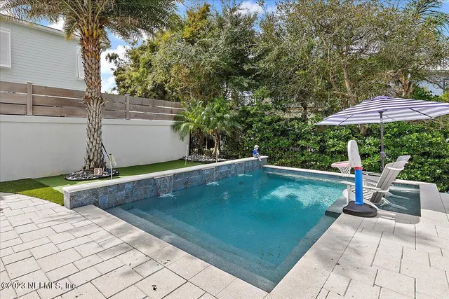 a view of a patio with a table and chairs under an umbrella
