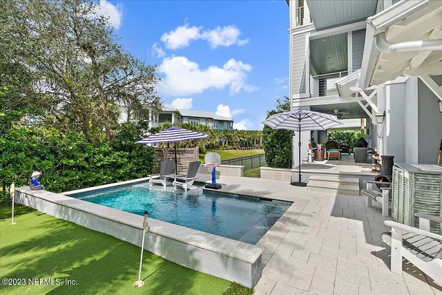 a view of a patio with table and chairs under an umbrella