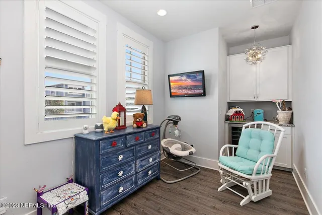 a living room with furniture to ceiling window and wooden floor
