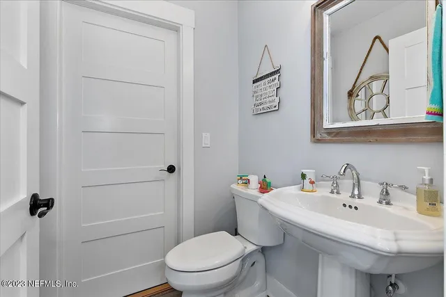 a bathroom with a sink mirror toilet and vanity