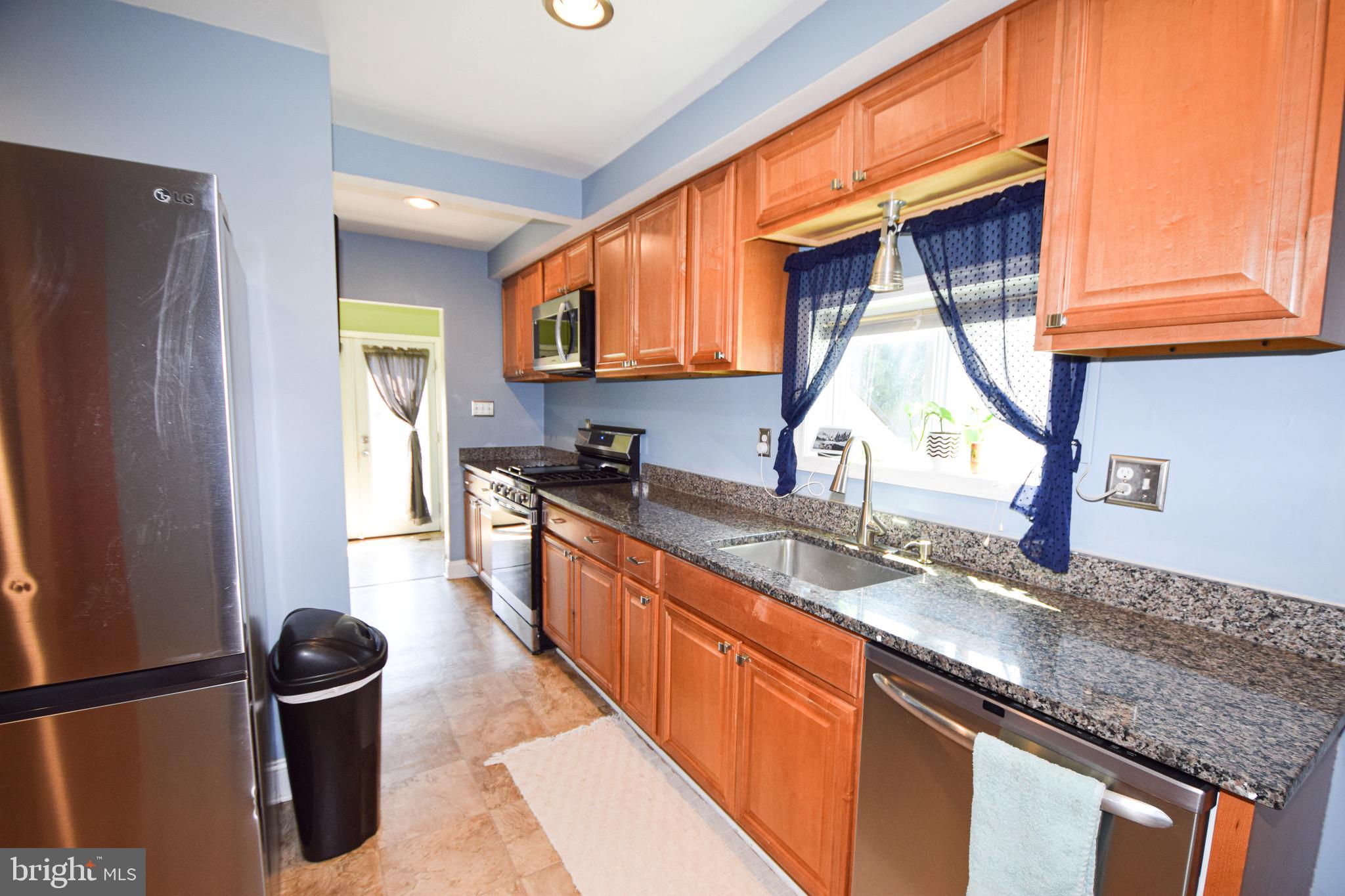 149 Post Road Aberdeen, MD 21001 - Photo 12 of 49 a kitchen with granite countertop a sink a stove and a refrigerator