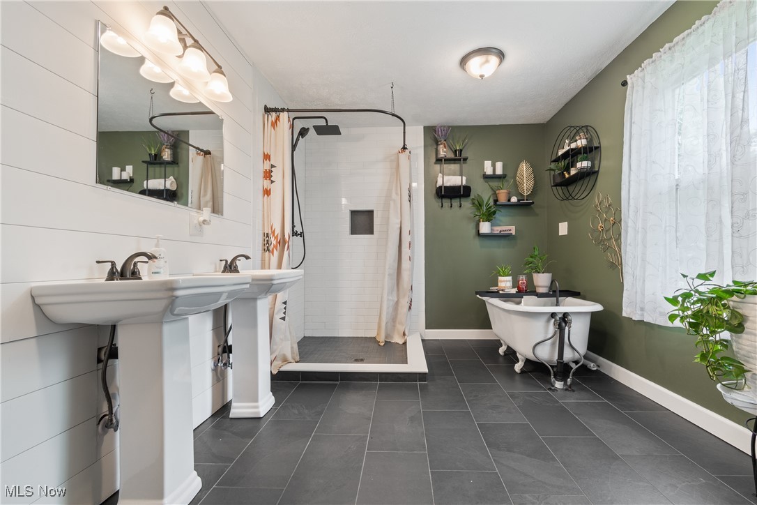 3609 Mahoning Road Northeast Canton, OH 44705 - Photo 15 of 31 Bathroom featuring dark tile patterned flooring, a shower stall, and a freestanding tub