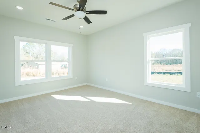 an empty room with a window and a fan