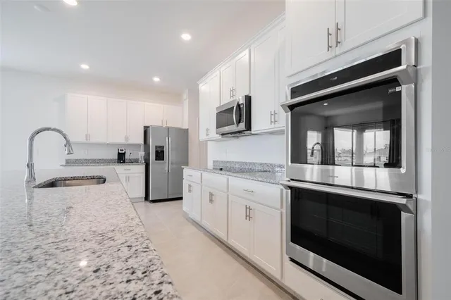 a kitchen with stainless steel appliances granite countertop a stove microwave and sink