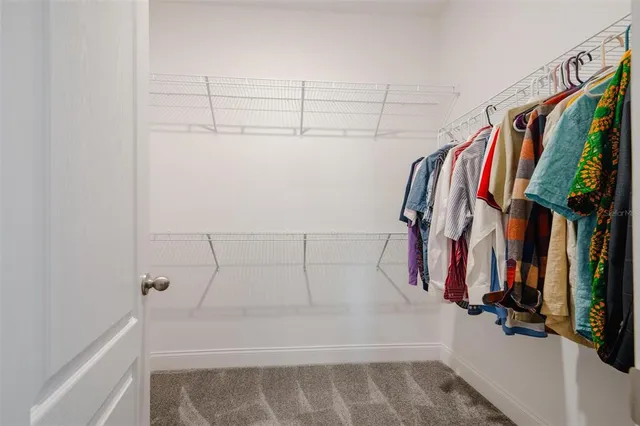 a view of walk in closet with clothes and shoes