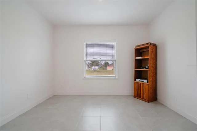 an empty room with closet and windows