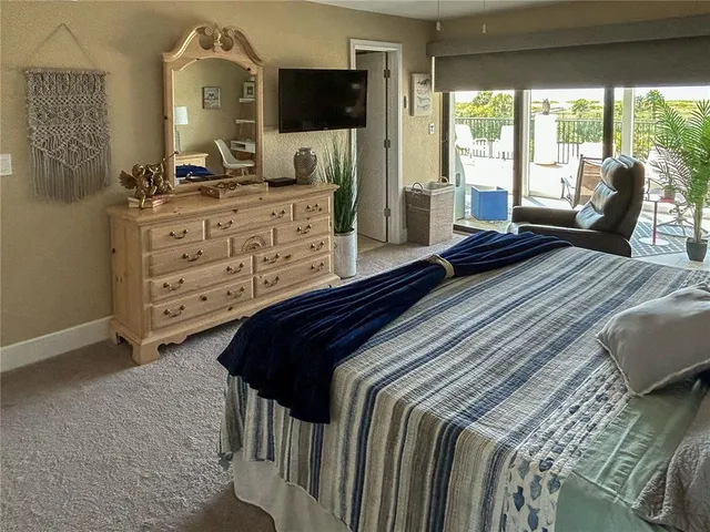 a bedroom with a bed and large windows