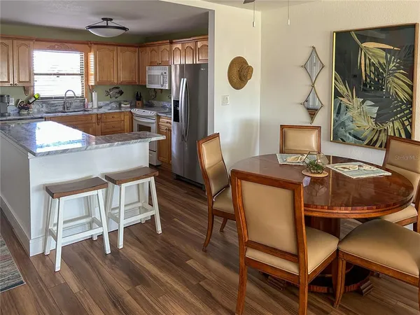 a kitchen with a table chairs and a wooden floor