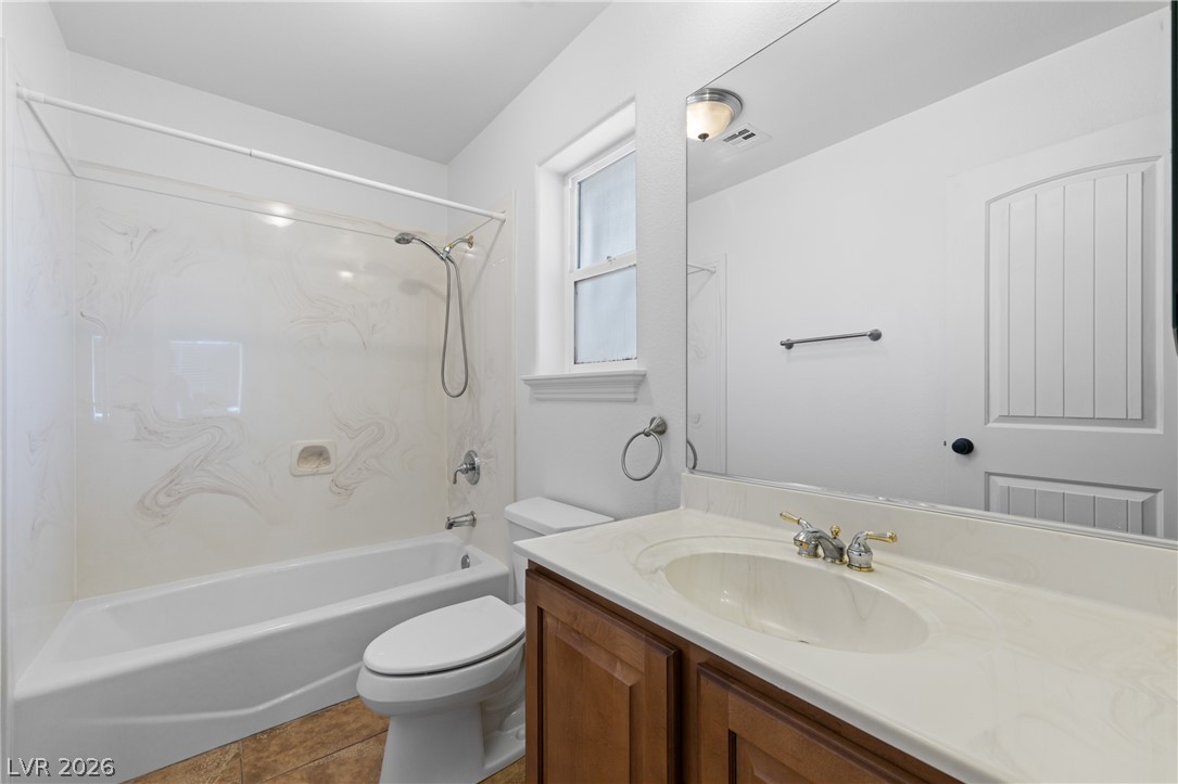 575 Gann Avenue Logandale, NV 89021 - Photo 45 of 75 A compact bath features a combined shower and tub, complemented by a wooden vanity and a broad mirror.