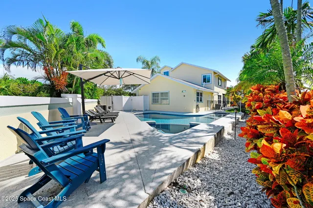 a front view of a house with a yard and potted plants