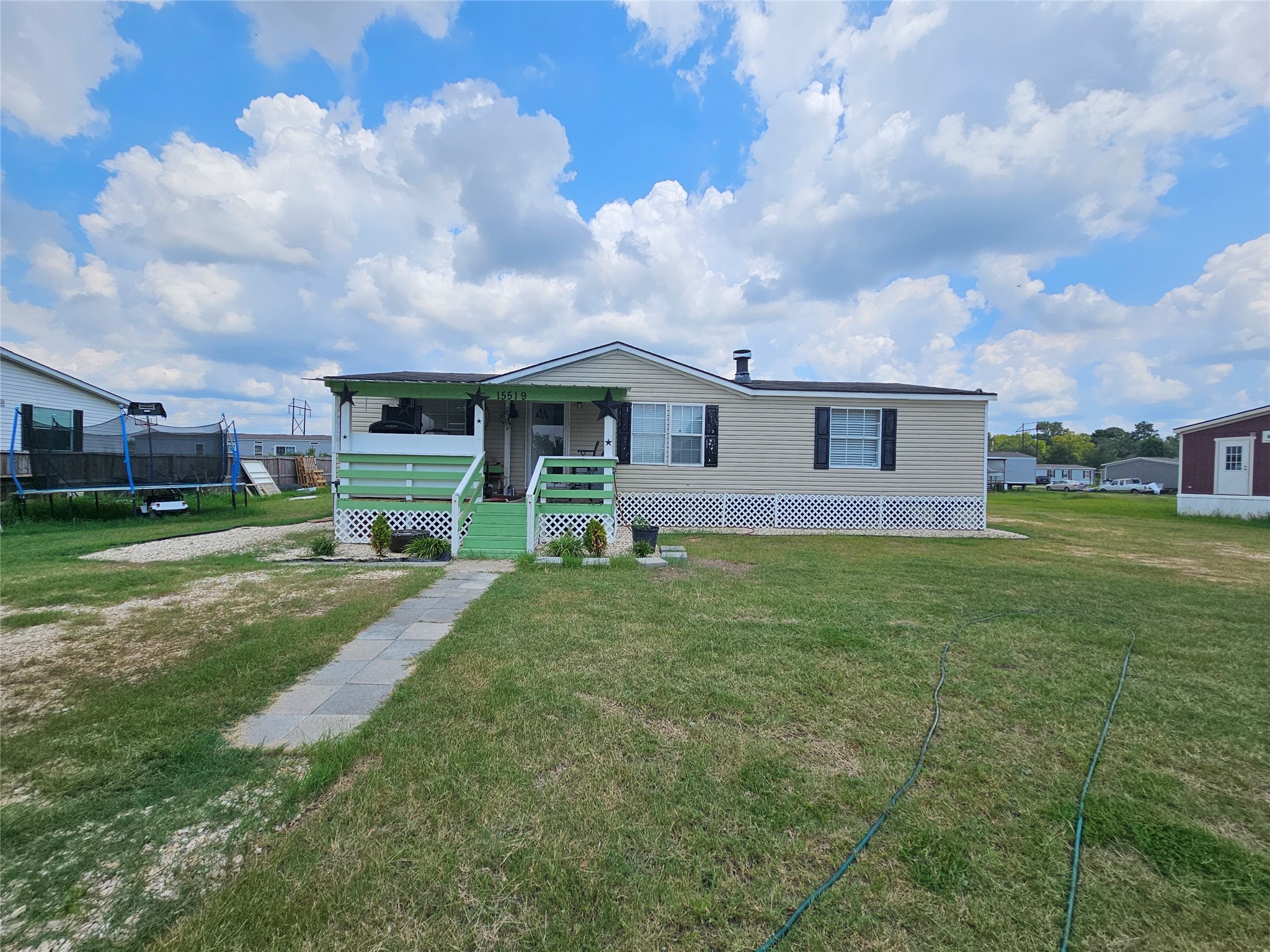 15519 Schank Road Conroe, TX 77306 - Photo 2 of 15 a view of a house with a big yard and a large tree