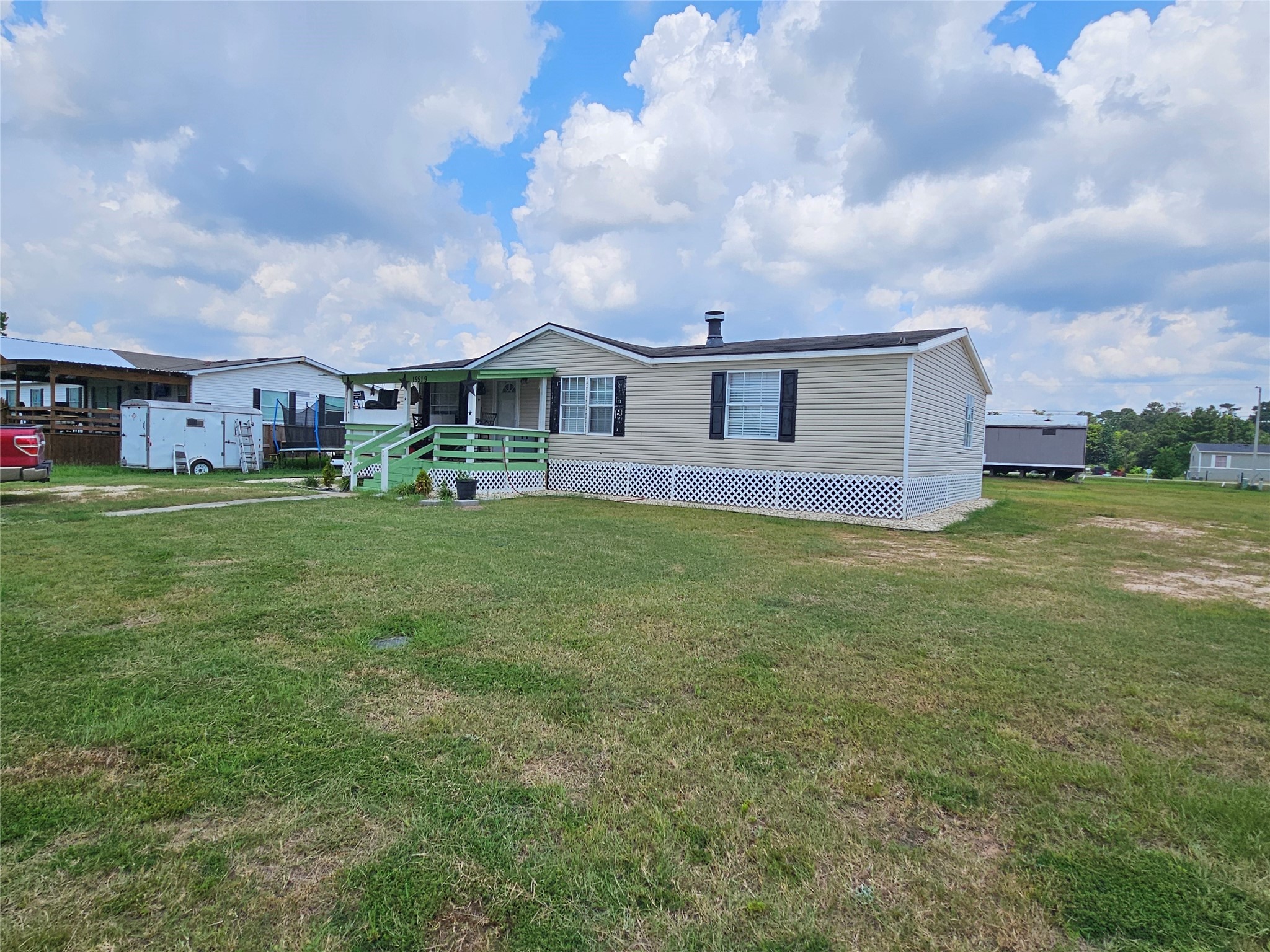15519 Schank Road Conroe, TX 77306 - Photo 3 of 15 a view of a house with a big yard and large trees