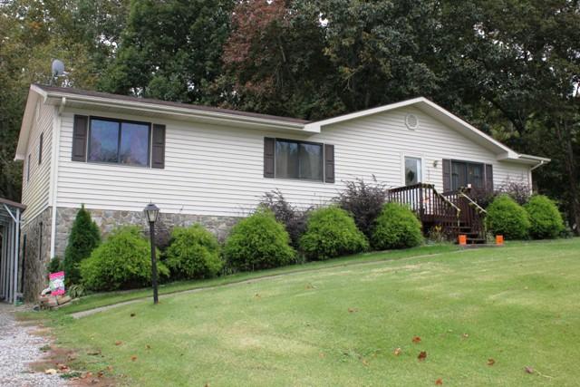 a view of a house with a yard and potted plants