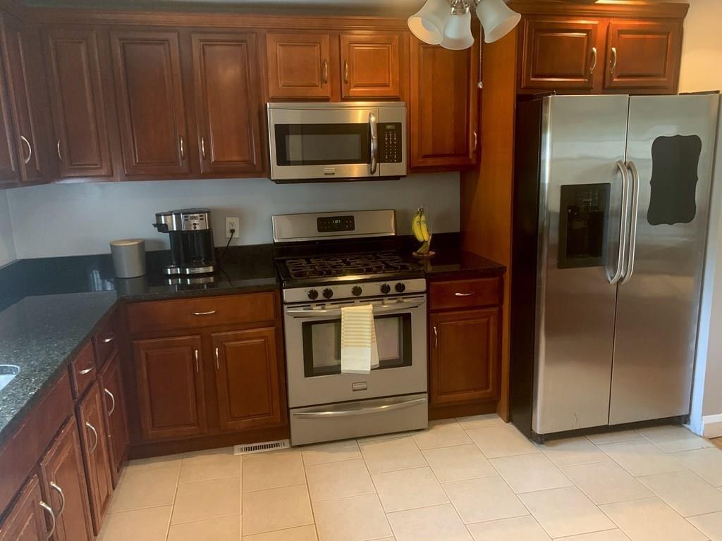239 Windemere Street Springfield, MA 01104 - Photo 10 of 32 a kitchen with stainless steel appliances granite countertop a stove microwave and refrigerator