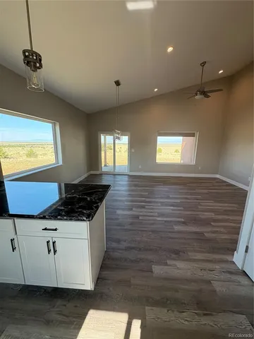 a view of a kitchen with a stove cabinets wooden floor and a ceiling fan