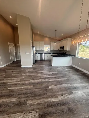 a large kitchen with stainless steel appliances a large counter top a stove a sink and a refrigerator