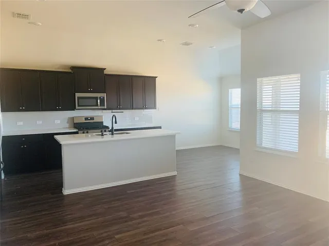 a kitchen with a sink cabinets and wooden floor