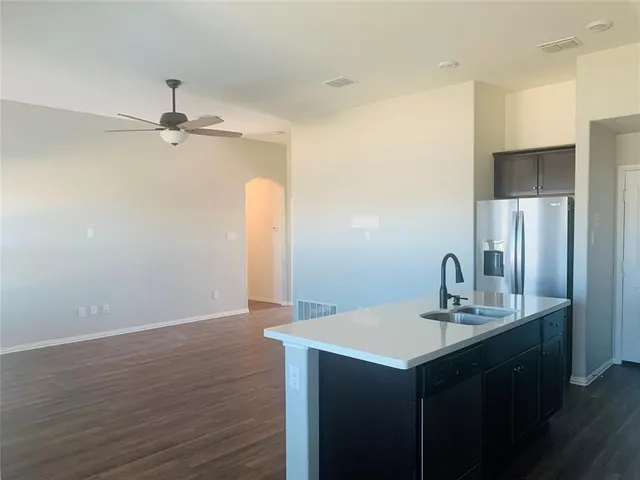 a kitchen with a sink refrigerator and chandelier