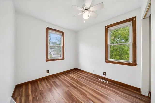 a view of empty room with window and ceiling fan