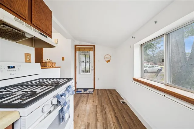 a kitchen with wooden floors and appliances