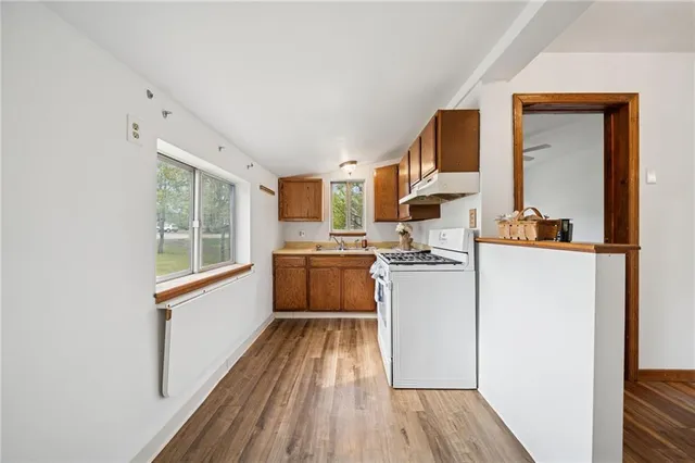 a kitchen with a refrigerator wooden floor and a sink