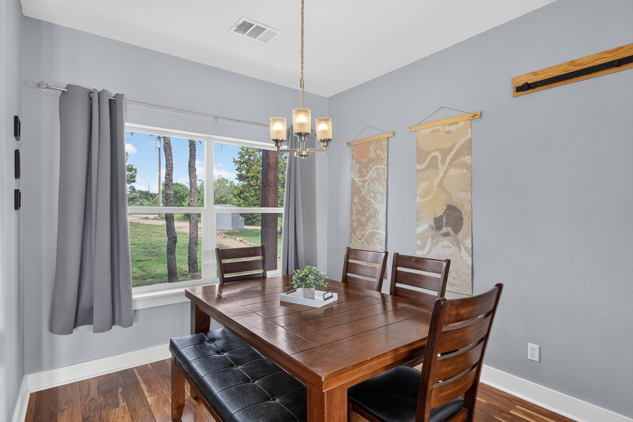 207 Deer Ridge Drive Burnet, TX 78611 - Photo 22 of 36 A refined dining space with wood floors, a multi-light chandelier, and an expansive window view.