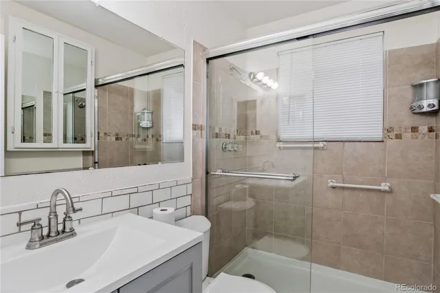 a bathroom with a shower sink and mirror