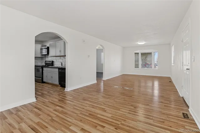 a view of empty room with wooden floor