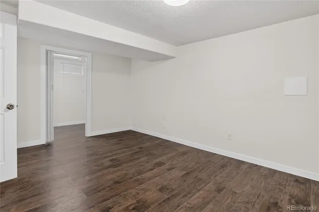 a view of an empty room with wooden floor