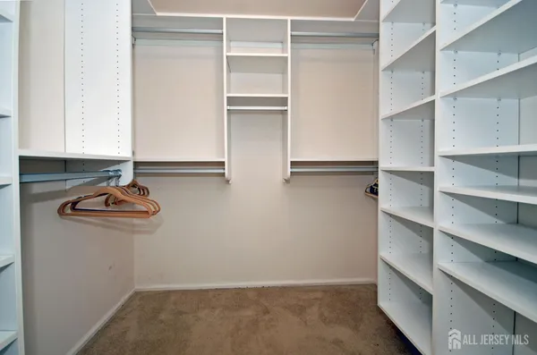 a view of cabinets and utility room with racks on the wall