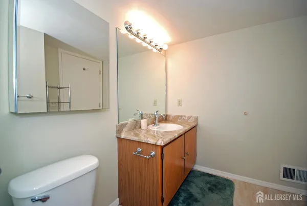 a bathroom with a granite countertop sink a toilet and mirror