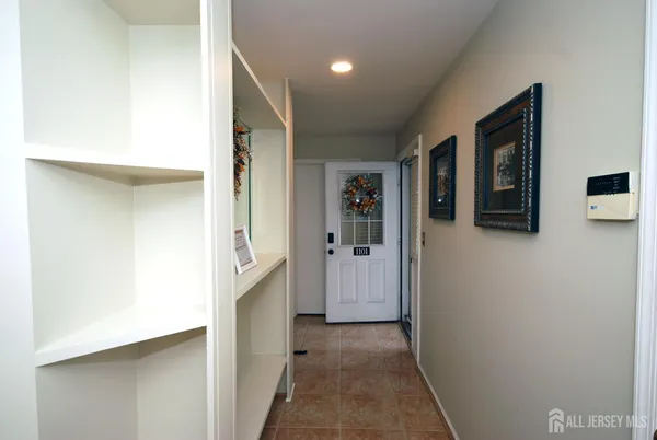 a view of a hallway with wooden shelves