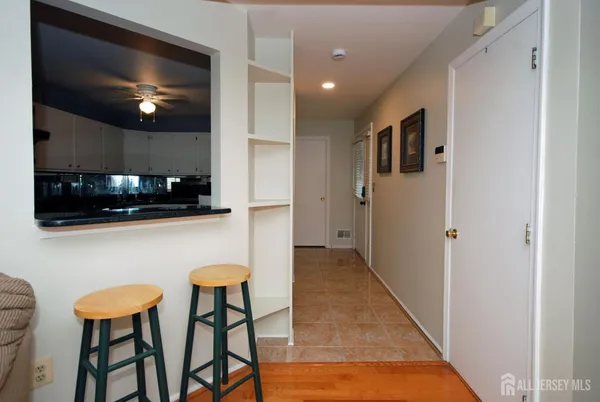 a kitchen with stainless steel appliances kitchen island granite countertop a dining table chairs and a refrigerator