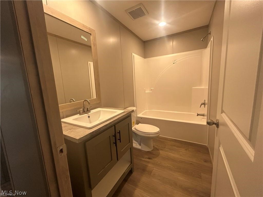 252 Front Street Philo, OH 43771 - Photo 14 of 17 Bathroom with vanity, dark wood-style floors, and bathing tub / shower combination