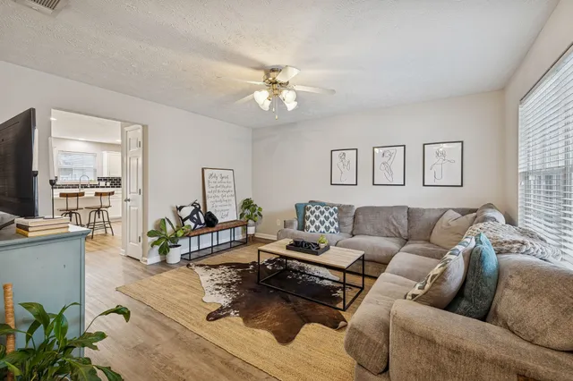 a living room with furniture and a wooden floor