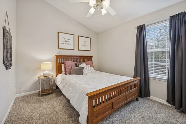 a bed sitting in a bedroom next to a window