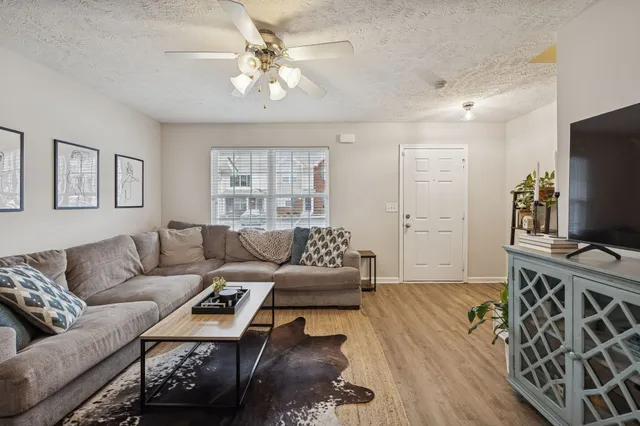 a living room with furniture a flat screen tv and a table