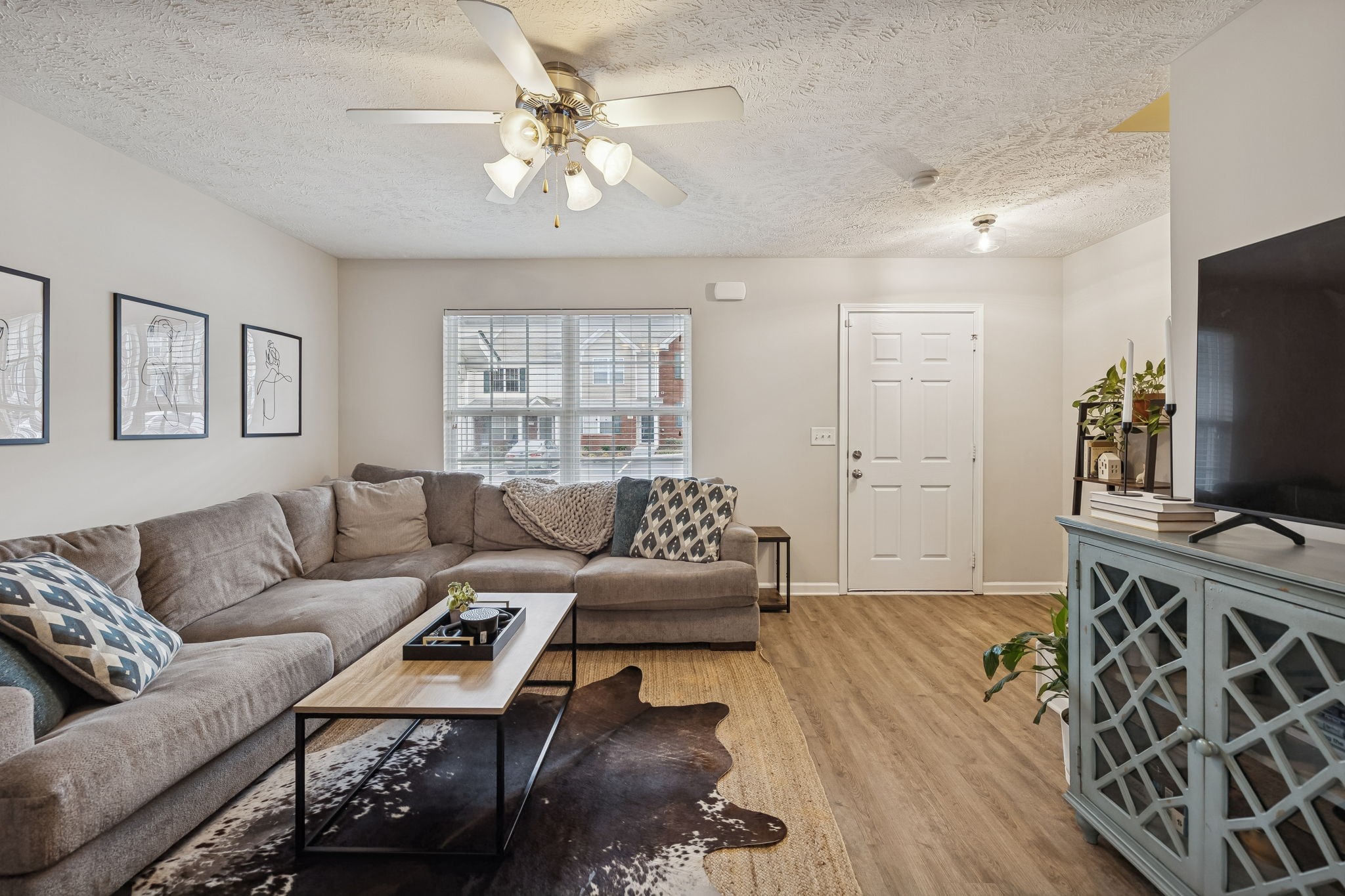 1834 Shaylin Loop Antioch, TN 37013 - Photo 7 of 28 a living room with furniture a flat screen tv and a table