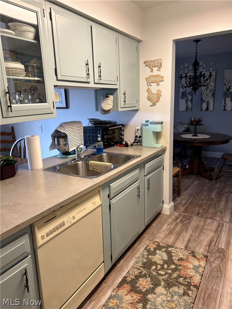8871 Clinton Road Cambridge, OH 43725 - Photo 11 of 33 Kitchen featuring light hardwood / wood-style floors, a notable chandelier, white dishwasher, and sink