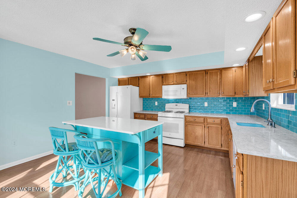 18 Mayapple Drive Brick, NJ 08724 - Photo 11 of 41 a kitchen with stainless steel appliances kitchen island granite countertop a table chairs in it and wooden floors