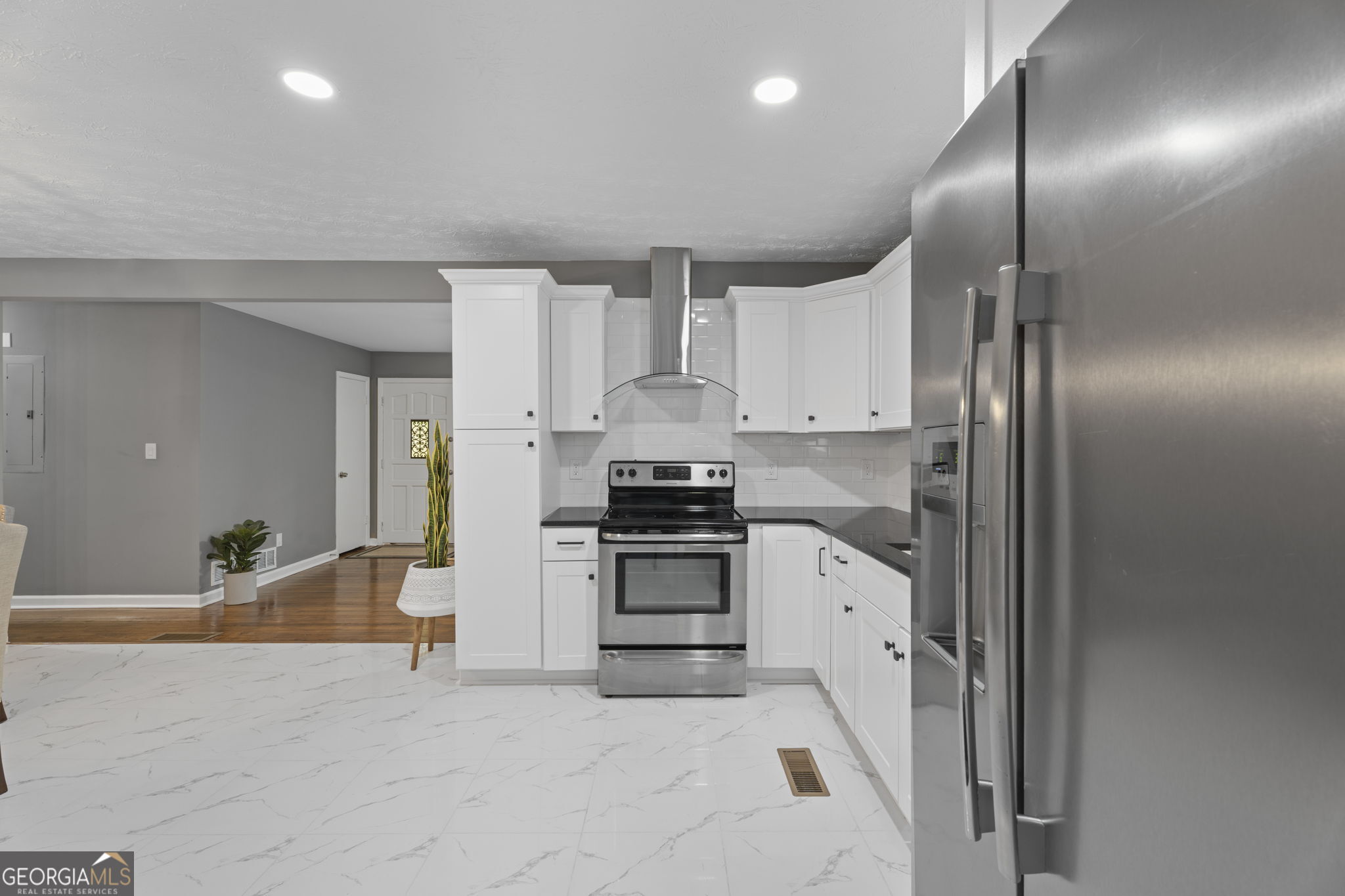 3567 Forrest Park Road Southeast Atlanta, GA 30354 - Photo 12 of 29 a kitchen with granite countertop a refrigerator stove and white cabinets