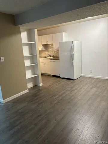a view of empty room with wooden floor and closet